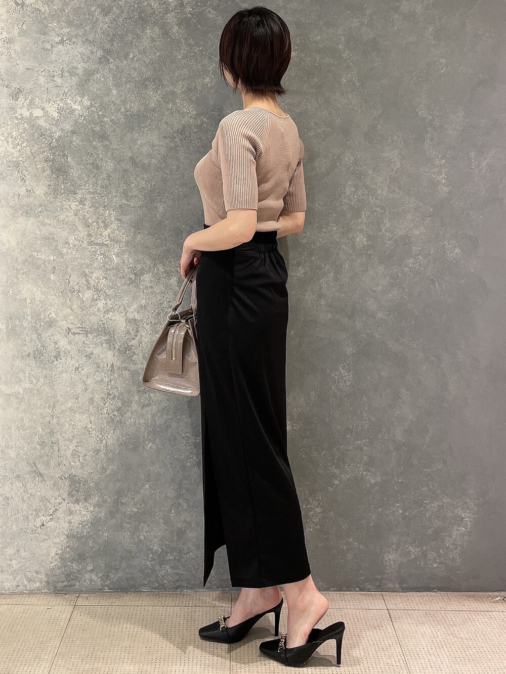 ブラック系のサンダル、ベージュ系のニット/セーター、ブラック系のスカートを着用したレディースの夏コーディネートの3枚目の写真