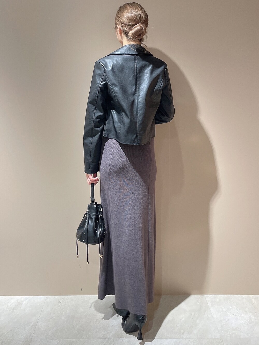 ブラック系のライダースジャケット、グレー系のワンピース、ブラック系のハンドバッグを着用したレディースの秋コーディネートの3枚目の写真