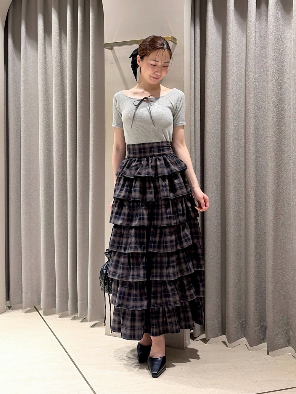 グレー系のTシャツ/カットソー、グレー系のスカート、ブラック系のパンプスを着用したレディースの夏コーディネートの3枚目の写真