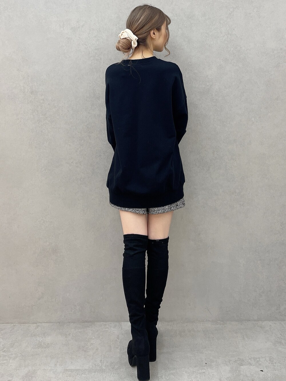 ブラック系のスウェット、ブラック系のブーツ、ブラック系のその他パンツを着用したレディースの秋コーディネートの3枚目の写真