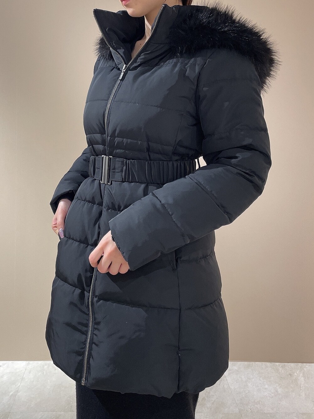 ブラック系のダウンジャケット/コート、ブラック系のワンピース、ブラック系のブーツを着用したレディースの秋コーディネートの4枚目の写真