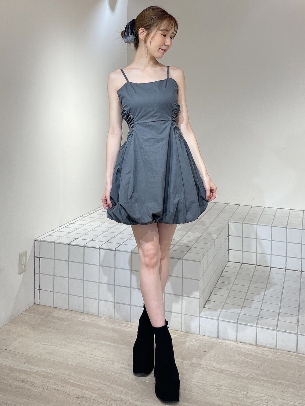 グレー系のワンピース、ブラック系のブーツ、グレー系のシュシュを着用したレディースの秋コーディネートの8枚目の写真