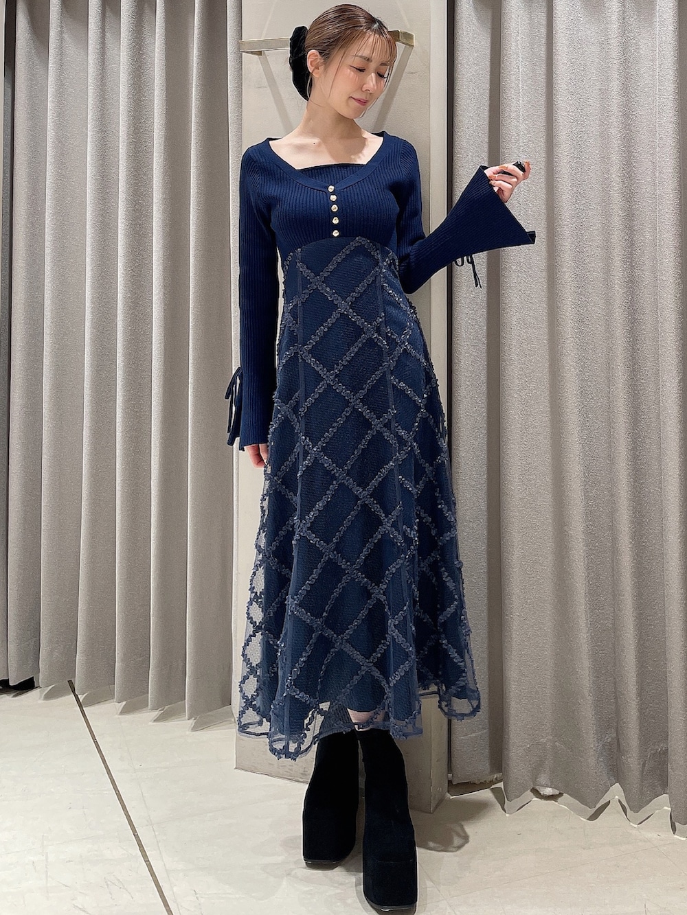 ブルー系のワンピース、ブラック系のブーツ、ブラック系のシュシュを着用したレディースの秋コーディネートの3枚目の写真