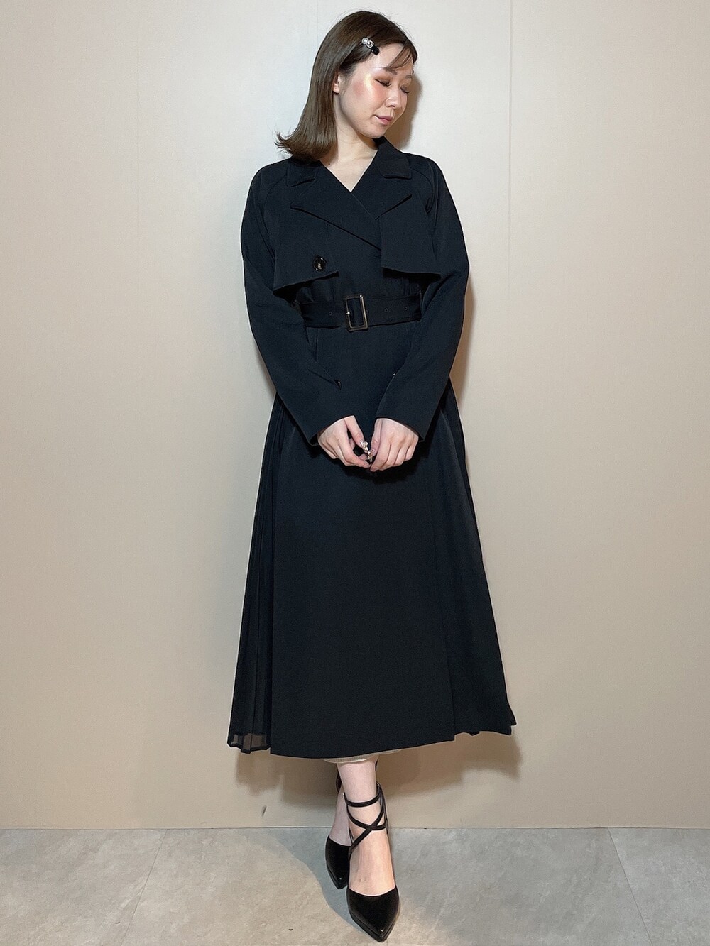 ブラック系のトレンチコート、ブラック系のパンプスを着用したレディースの冬コーディネートの3枚目の写真