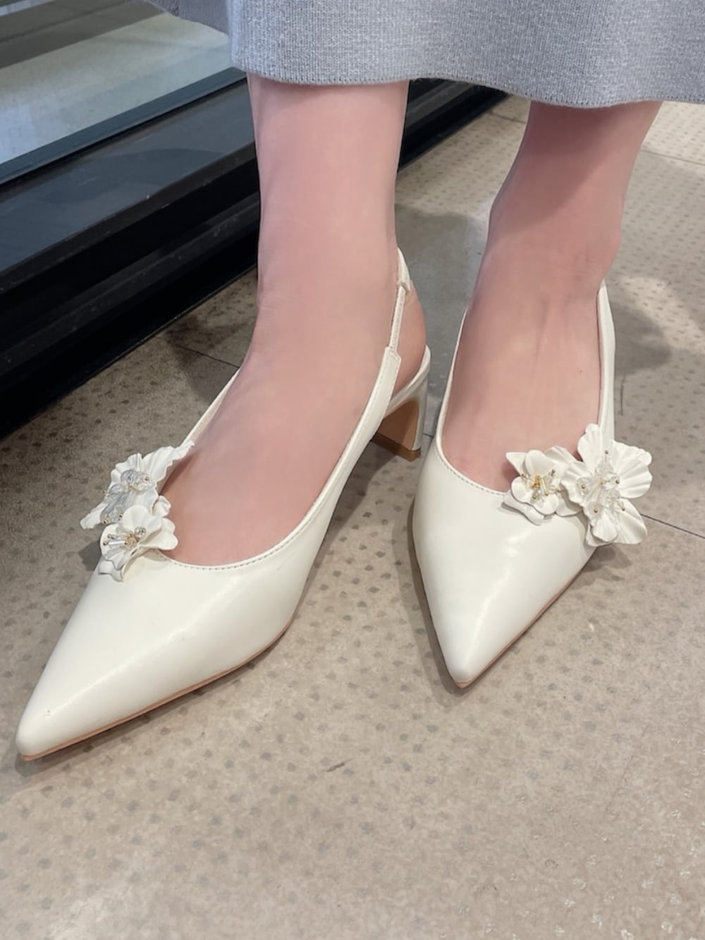 ホワイト系のテーラードジャケット、パープル系のニット/セーター、ホワイト系のスカートを着用したレディースの冬コーディネートの9枚目の写真