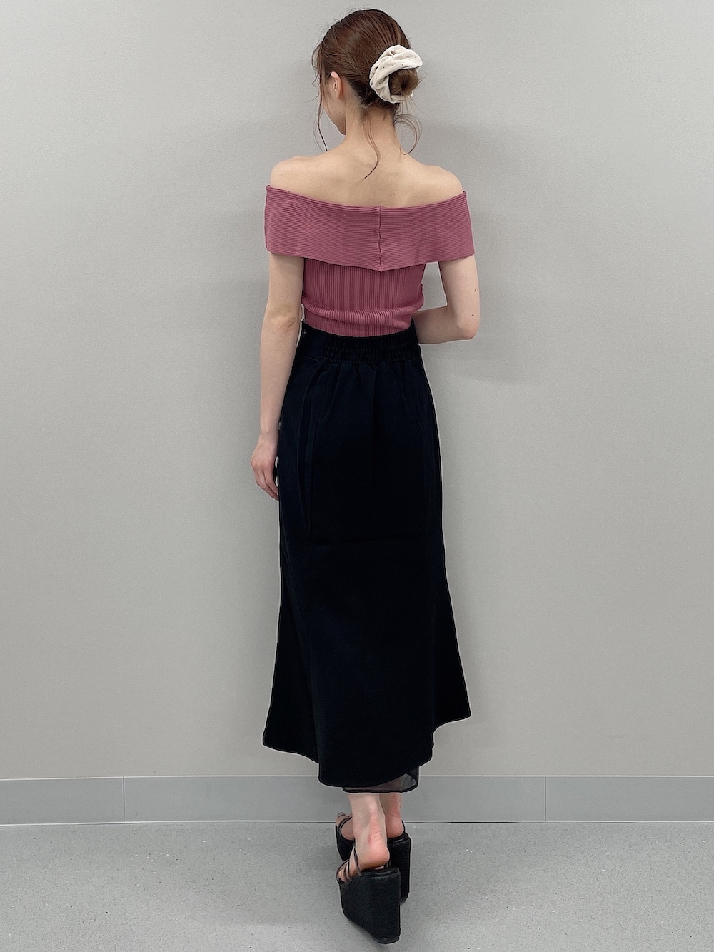 ピンク系のニット/セーター、ブラック系のスカート、ブラック系のサンダルを着用したレディースの春コーディネートの3枚目の写真