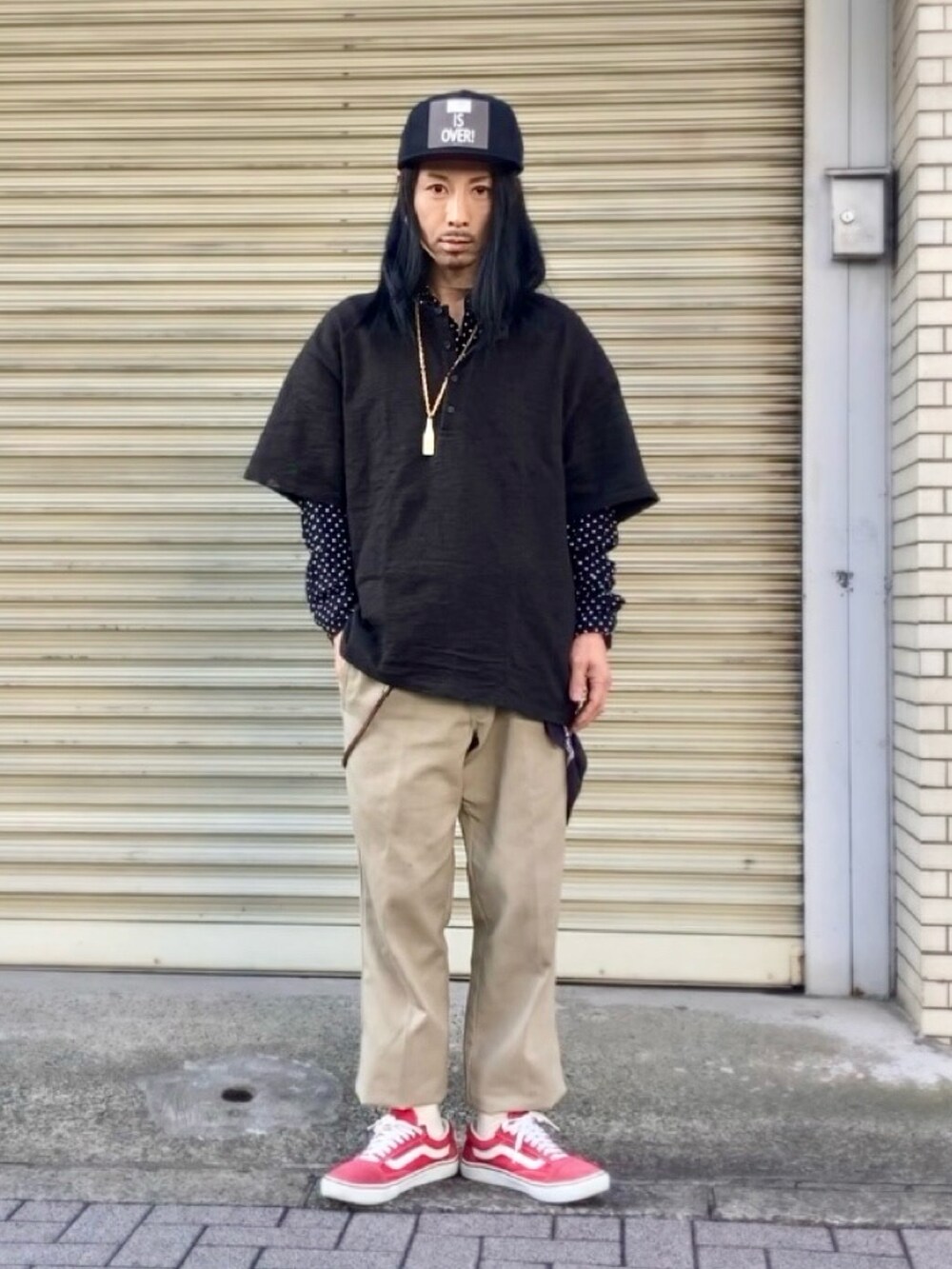 ベージュ系のチノパンツ、レッド系のスニーカー、ブラック系のTシャツ/カットソーを着用したメンズの春コーディネートの4枚目の写真