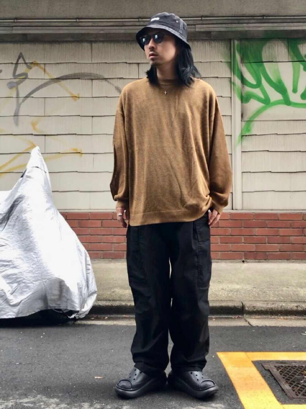 ベージュ系のニット/セーター、ブラック系のカーゴパンツ、ブラック系のサンダルを着用したメンズの秋コーディネートの4枚目の写真