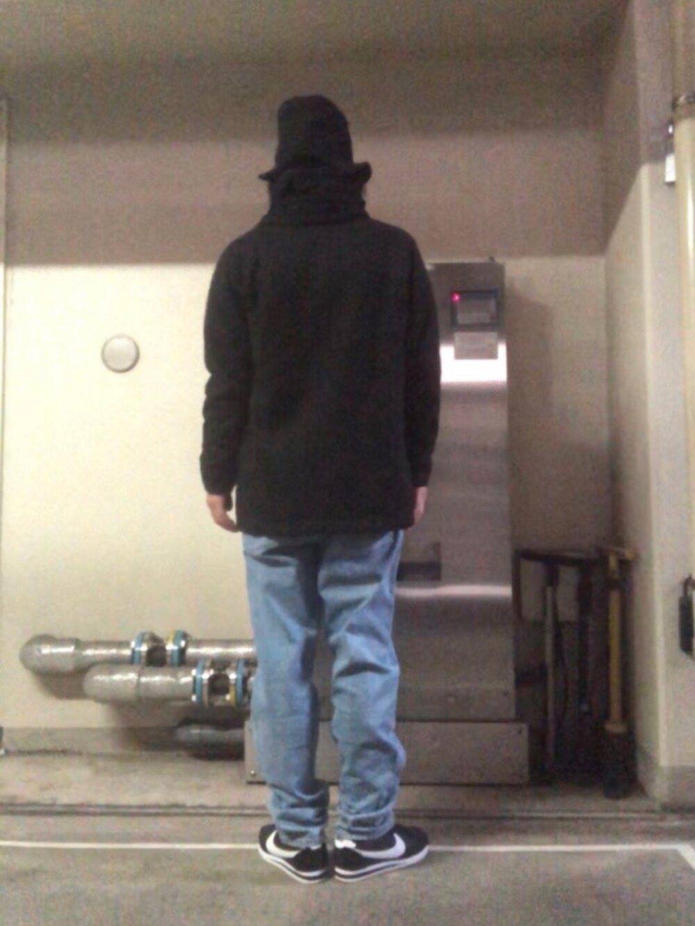 ブルー系のデニムパンツ、ブラック系のスニーカー、ブラック系のストール/ショールを着用したメンズの秋コーディネートの3枚目の写真