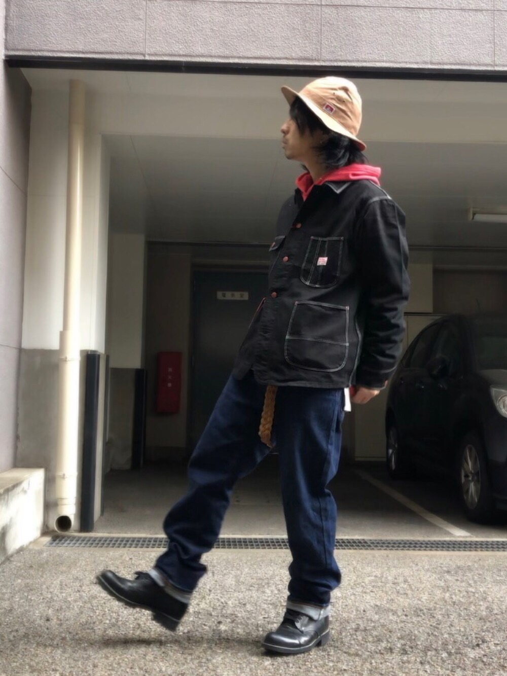 ブラック系のブーツ、ブラック系のカバーオール、ベージュ系のベルトを着用したメンズの春コーディネートの5枚目の写真