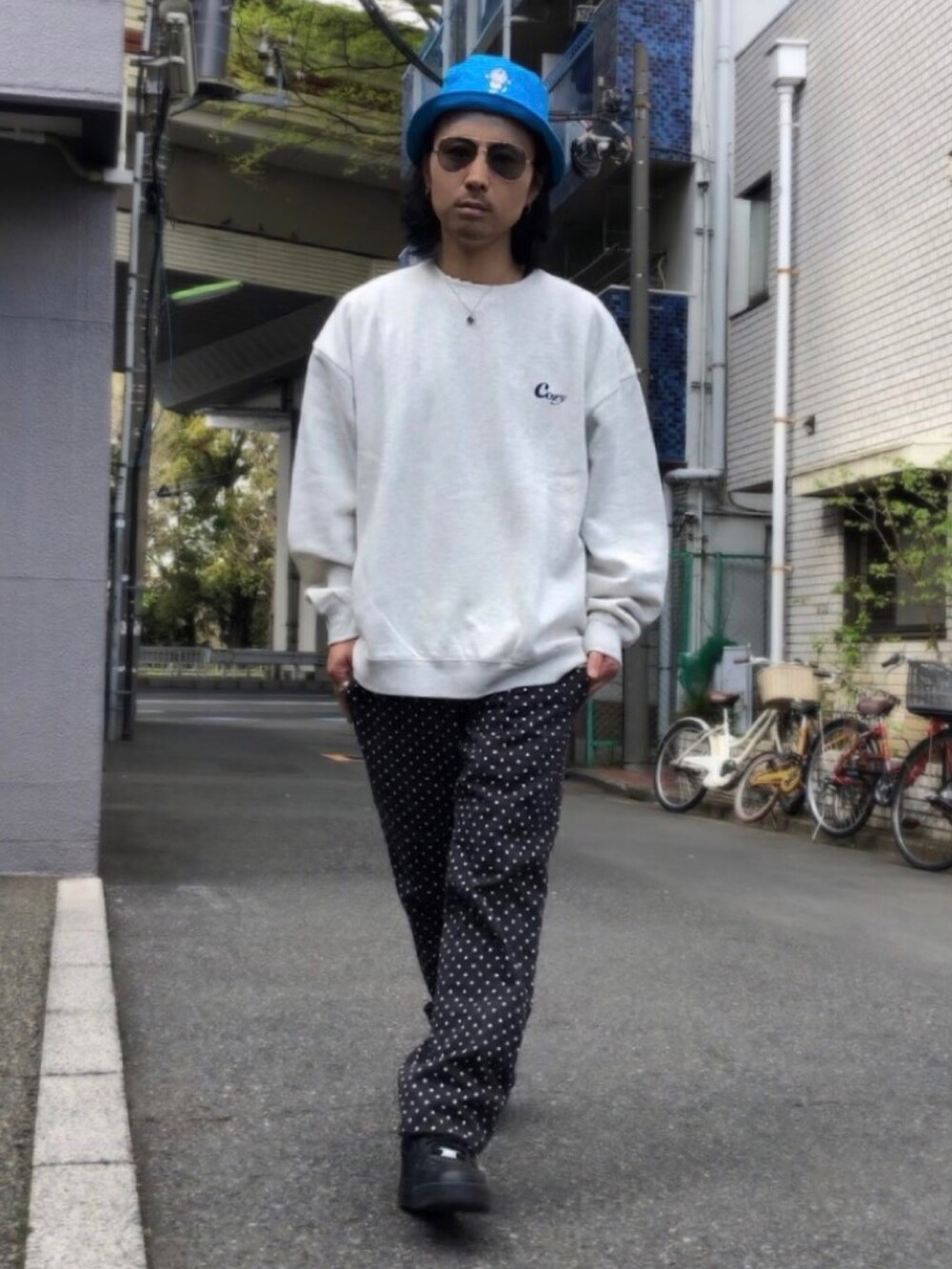 ホワイト系のスニーカー、ベージュ系のスウェット、ブラック系のチノパンツを着用したメンズの春コーディネートの5枚目の写真