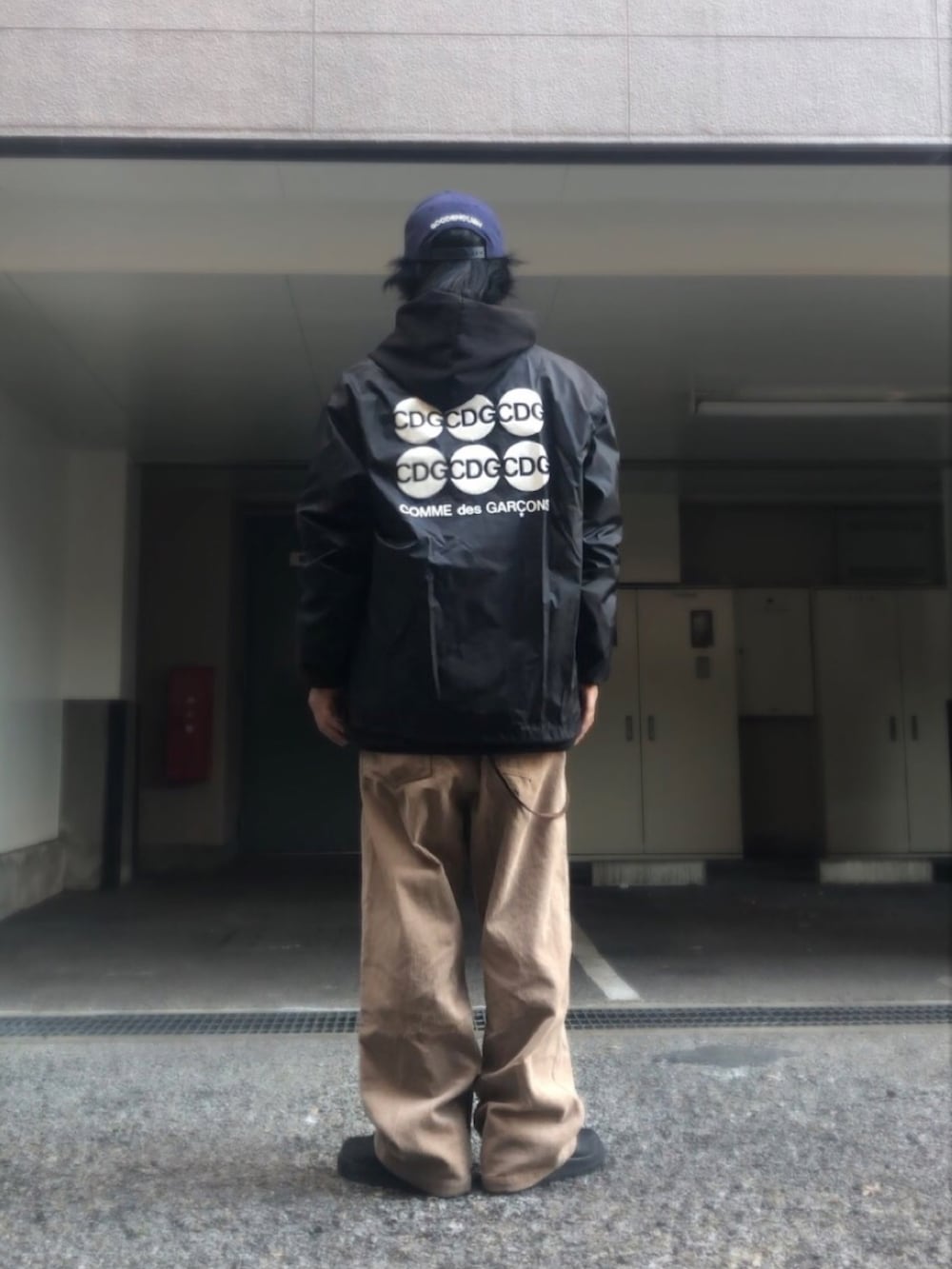 ブラック系のナイロンジャケット、ホワイト系のスニーカー、ベージュ系のベルトを着用したメンズの冬コーディネートの3枚目の写真