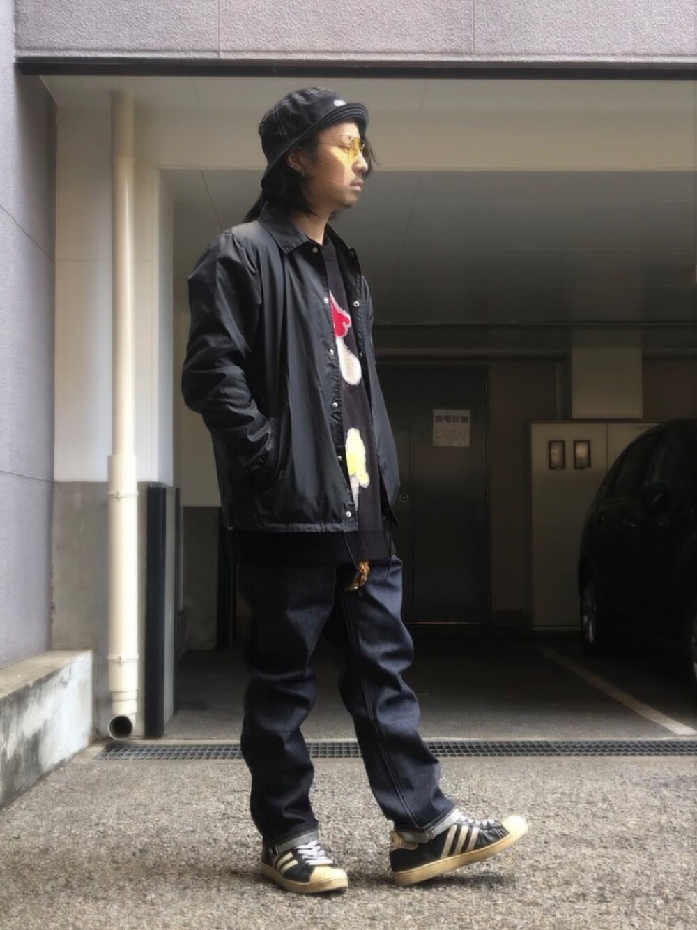 ブラック系のナイロンジャケット、ブラック系のニット/セーター、ブラック系のスニーカーを着用したメンズの冬コーディネートの4枚目の写真