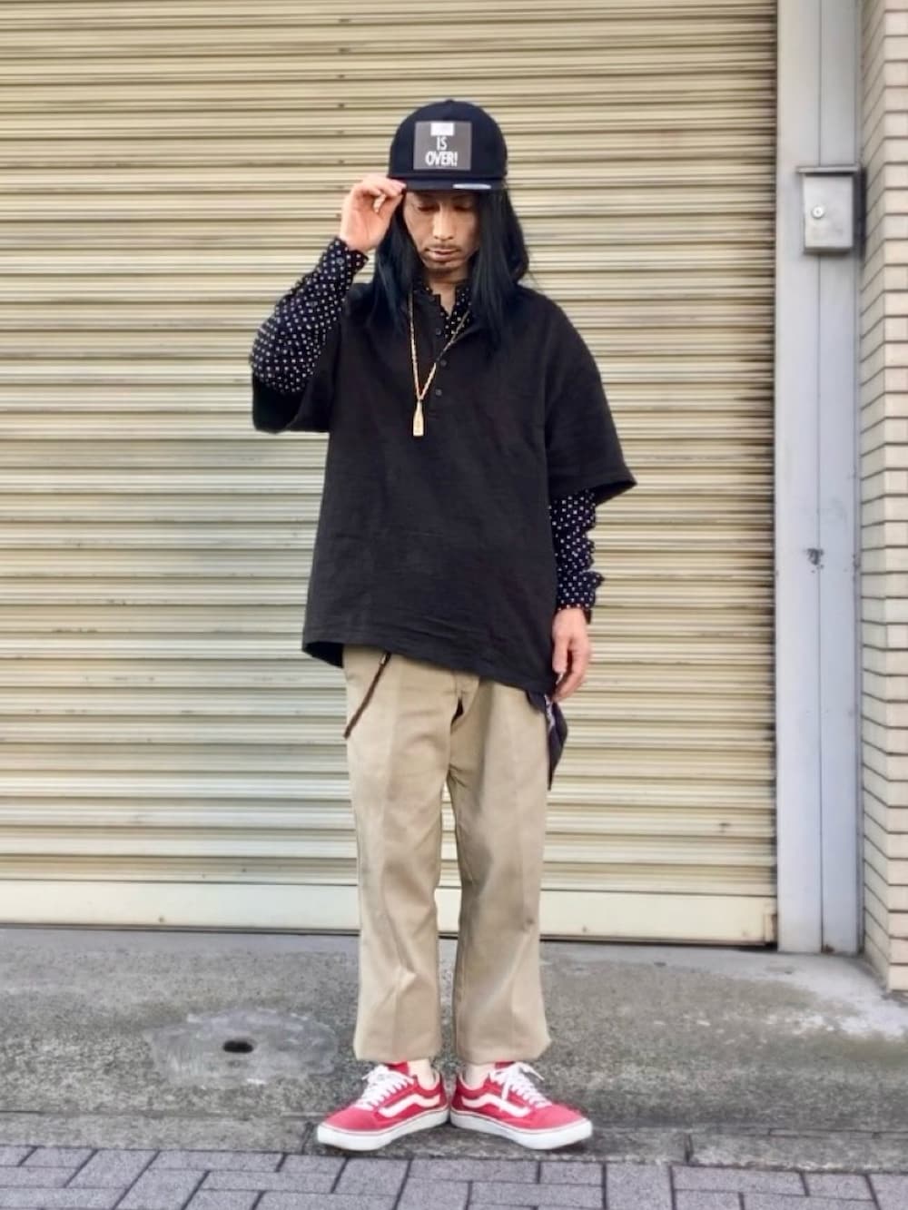 ベージュ系のチノパンツ、レッド系のスニーカー、ブラック系のTシャツ/カットソーを着用したメンズの春コーディネートの5枚目の写真