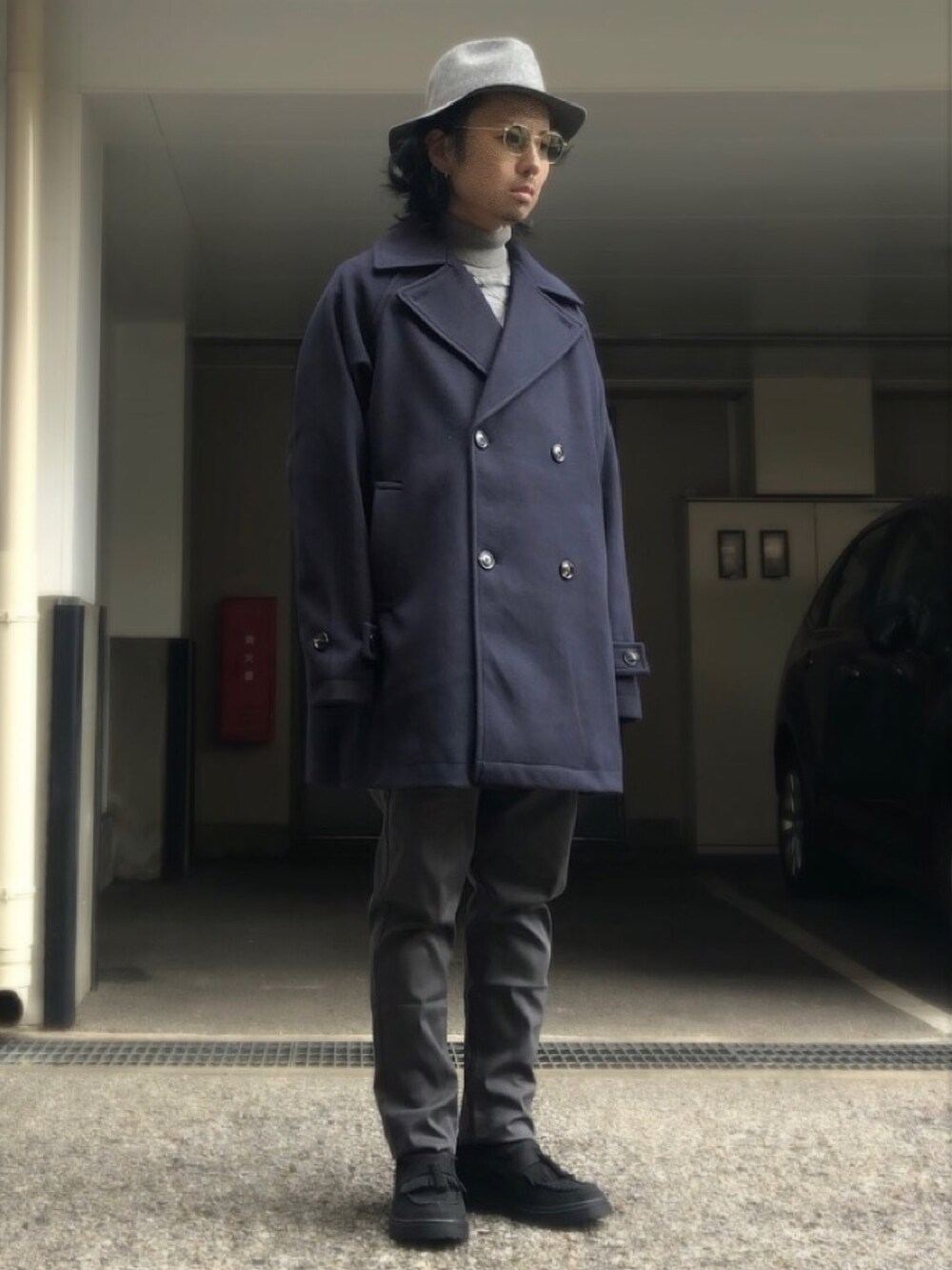 ブルー系のピーコート、ブラック系のローファー、シルバー系のネックレスを着用したメンズの冬コーディネートの4枚目の写真