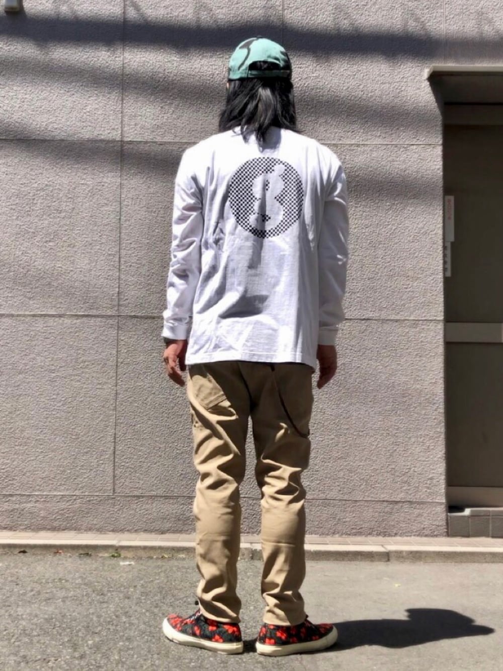 ホワイト系のTシャツ/カットソー、ベージュ系のチノパンツ、その他のスニーカーを着用したメンズの春コーディネートの3枚目の写真