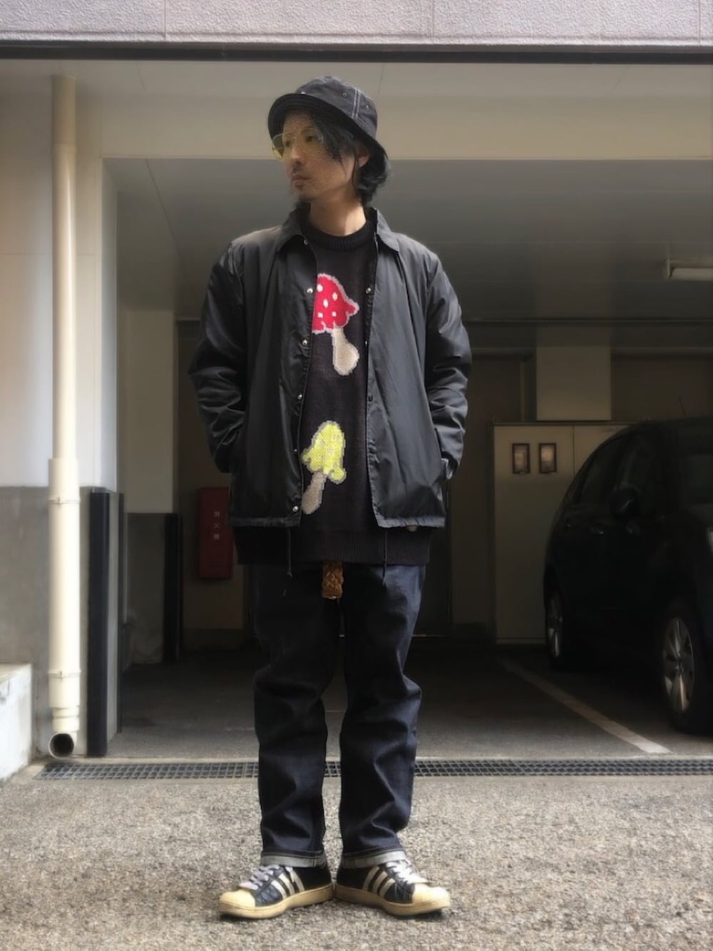 ブラック系のナイロンジャケット、ブラック系のニット/セーター、ブラック系のスニーカーを着用したメンズの冬コーディネートの5枚目の写真