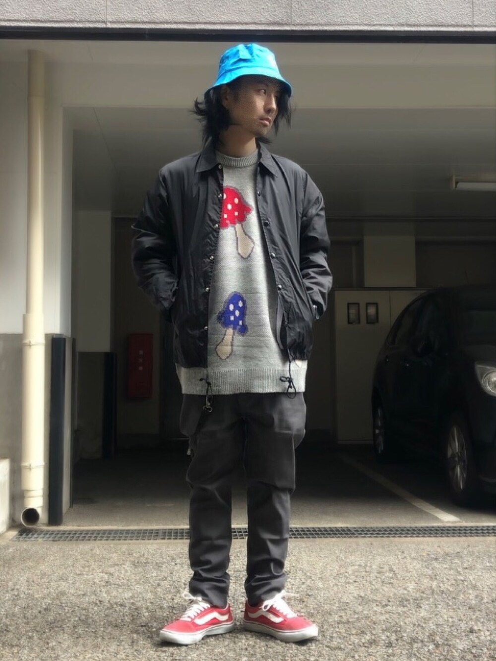 グレー系のニット/セーター、ブラック系のナイロンジャケット、レッド系のスニーカーを着用したメンズの冬コーディネートの4枚目の写真