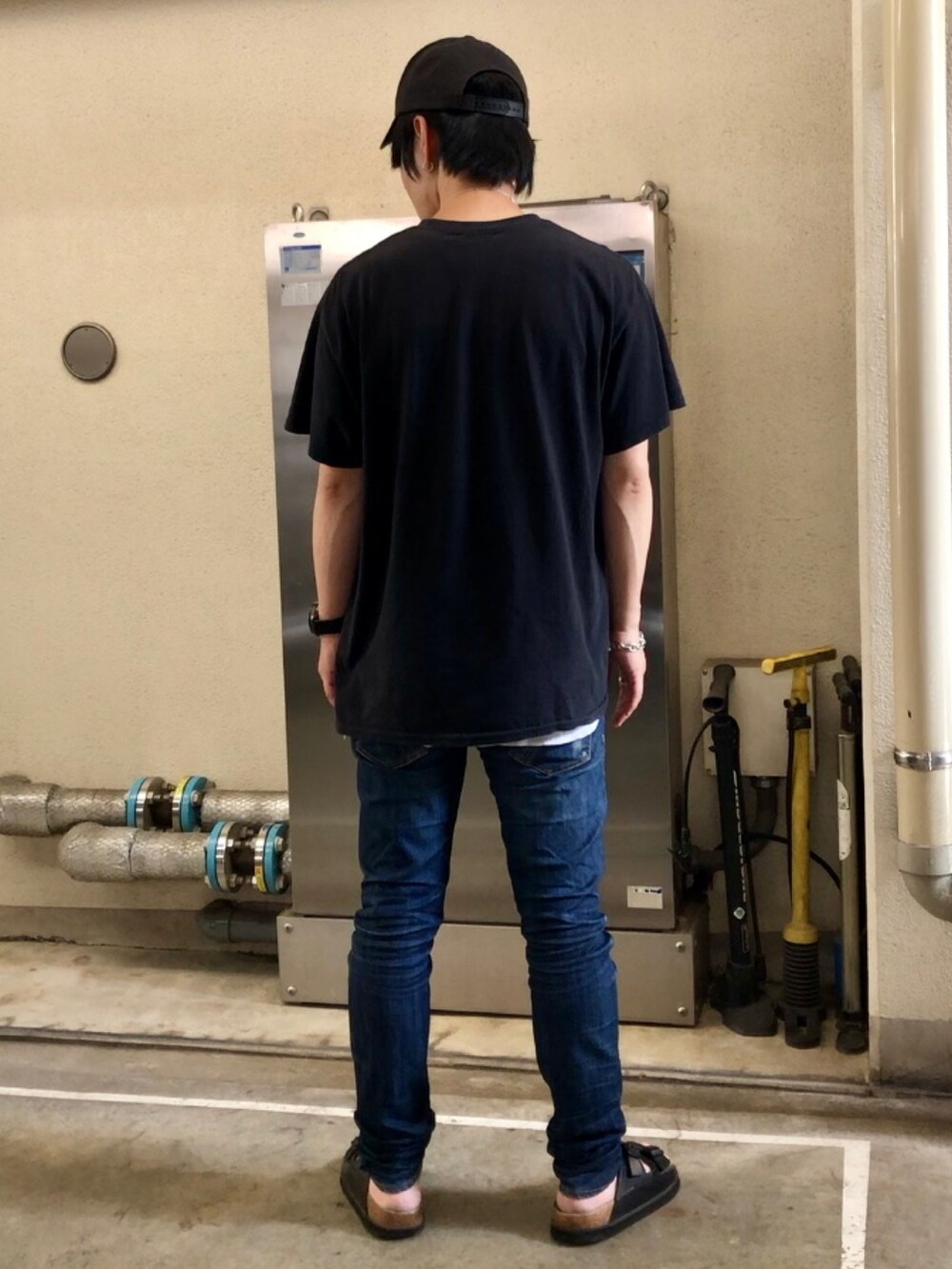 ブラック系のTシャツ/カットソー、ブルー系のデニムパンツ、ブラック系のキャップを着用したメンズの夏コーディネートの3枚目の写真