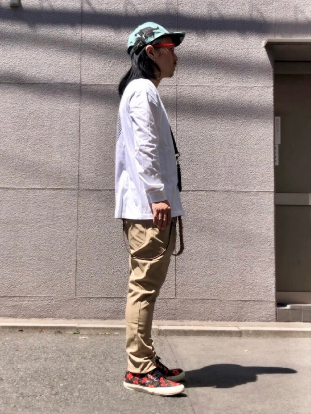 ホワイト系のTシャツ/カットソー、ベージュ系のチノパンツ、その他のスニーカーを着用したメンズの春コーディネートの2枚目の写真