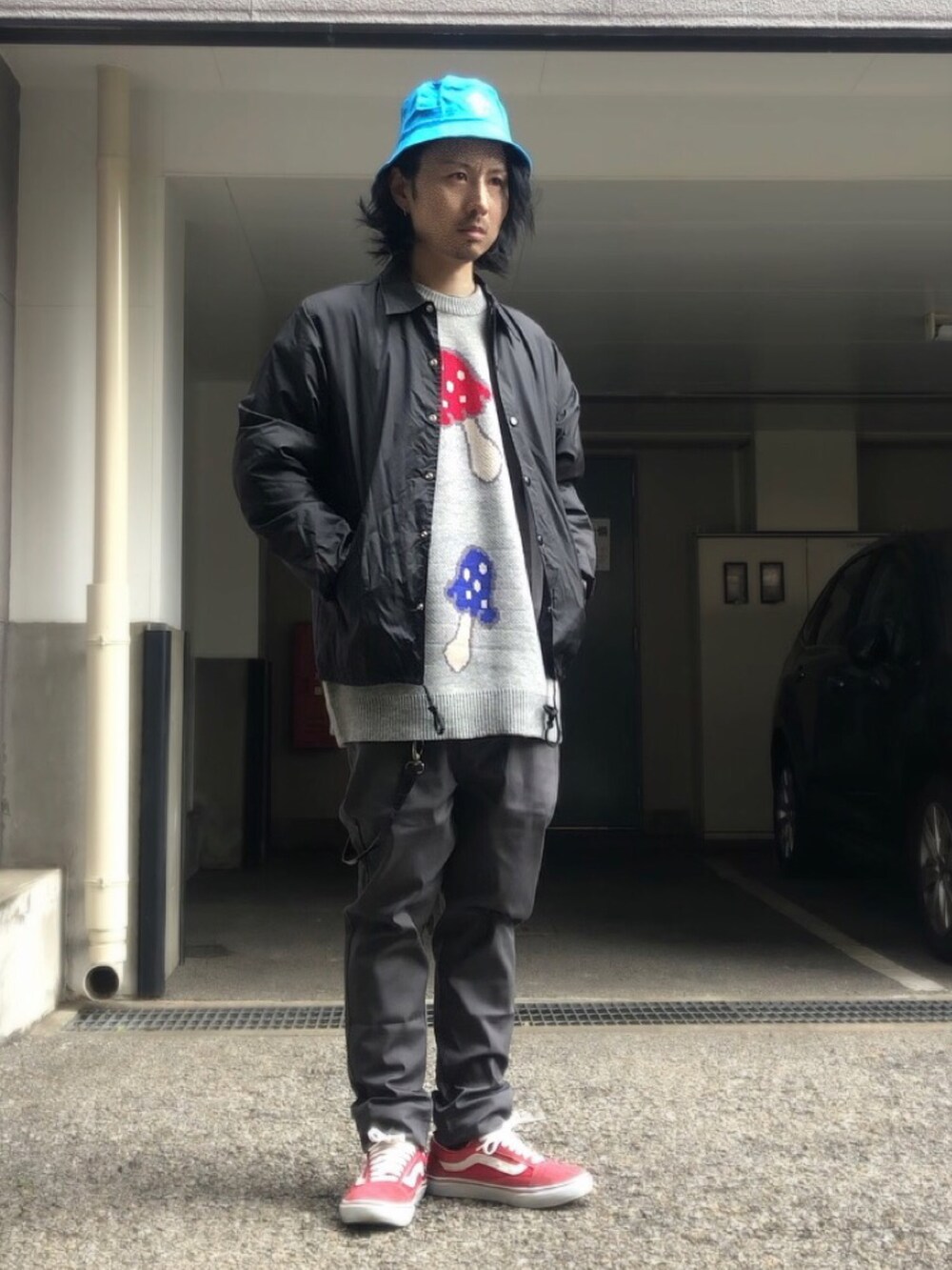 グレー系のニット/セーター、ブラック系のナイロンジャケット、レッド系のスニーカーを着用したメンズの冬コーディネートの5枚目の写真