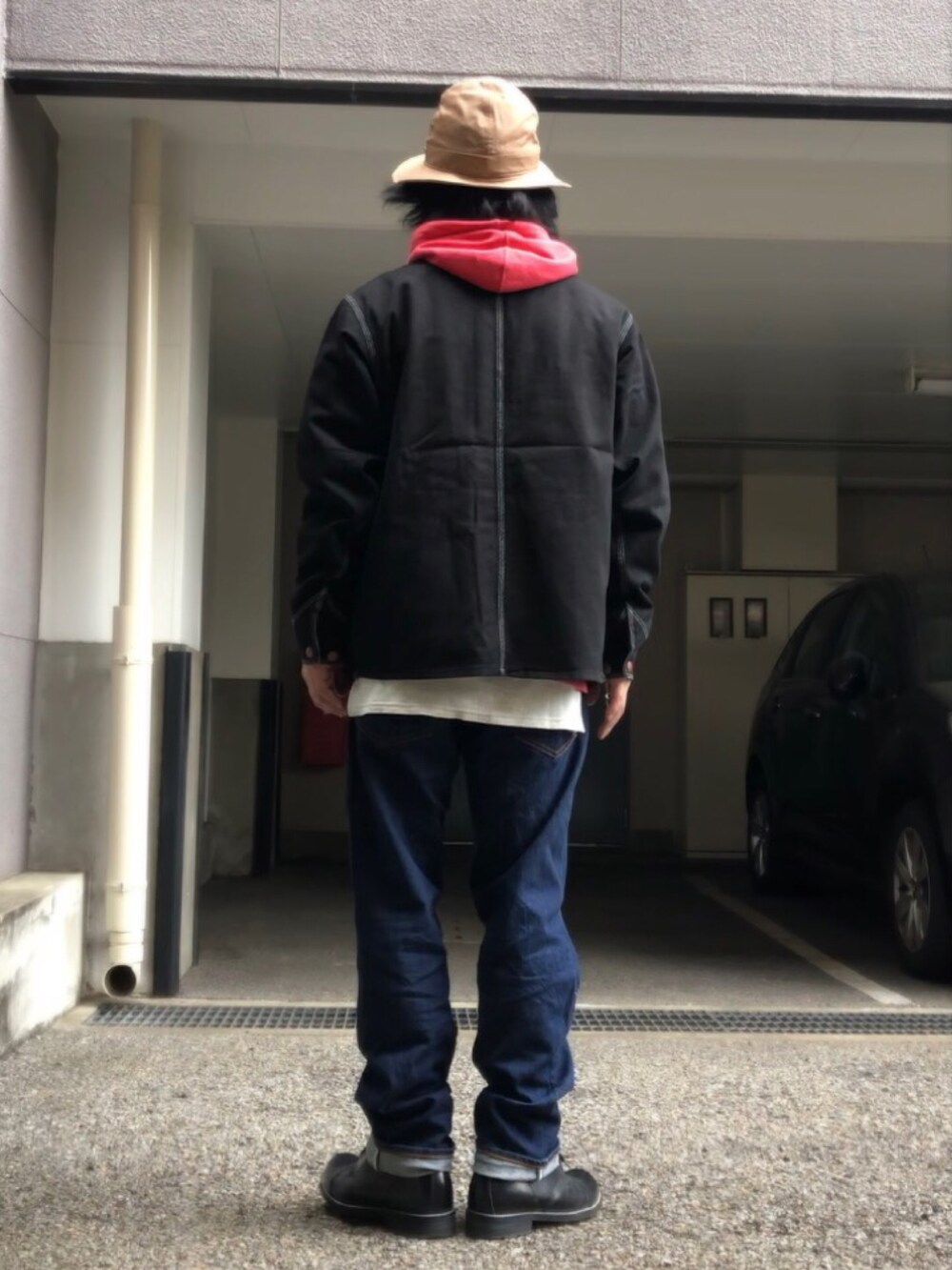 ブラック系のブーツ、ブラック系のカバーオール、ベージュ系のベルトを着用したメンズの春コーディネートの3枚目の写真