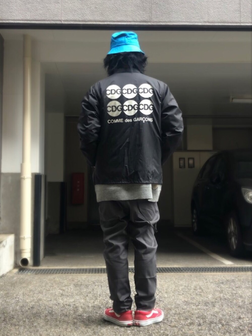 グレー系のニット/セーター、ブラック系のナイロンジャケット、レッド系のスニーカーを着用したメンズの冬コーディネートの3枚目の写真