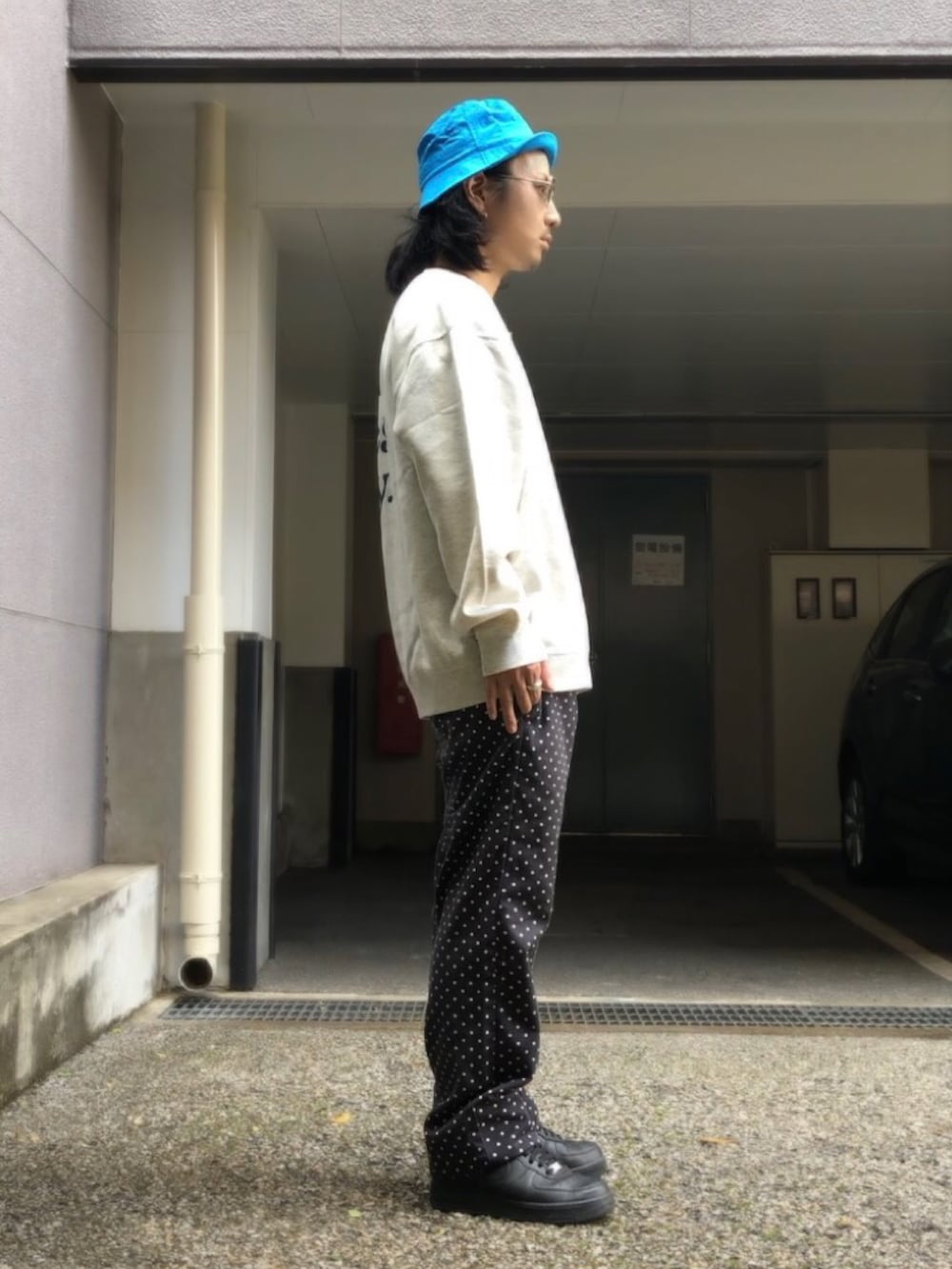 ホワイト系のスニーカー、ベージュ系のスウェット、ブラック系のチノパンツを着用したメンズの春コーディネートの2枚目の写真