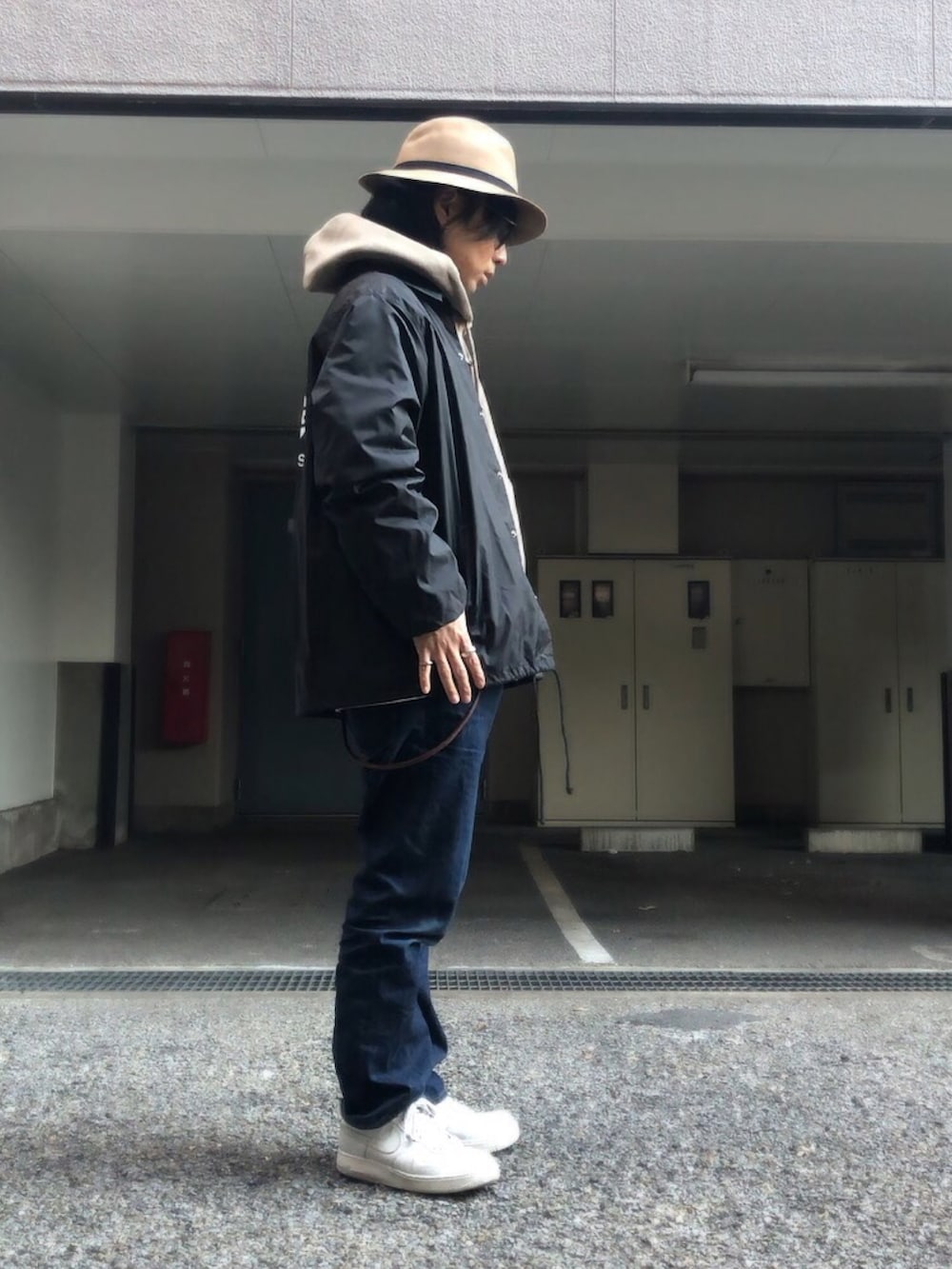 ホワイト系のスニーカー、ベージュ系のハット、ブラウン系のバングル/リストバンドを着用したメンズの冬コーディネートの2枚目の写真