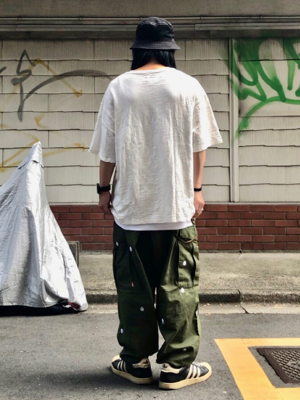 ホワイト系のTシャツ/カットソー、グリーン系のカーゴパンツ、ブラック系のスニーカーを着用したメンズの秋コーディネートの4枚目の写真