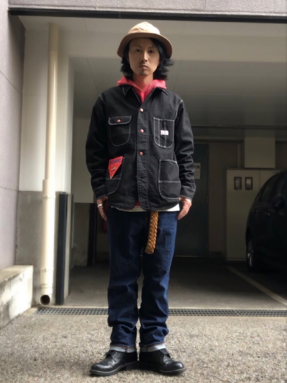 ブラック系のブーツ、ブラック系のカバーオール、ベージュ系のベルトを着用したメンズの春コーディネートの4枚目の写真