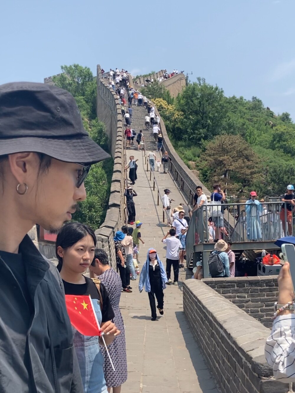 ブラック系のスニーカー、ホワイト系のハット、シルバー系のピアス（片耳用）を着用したメンズの夏コーディネートの3枚目の写真