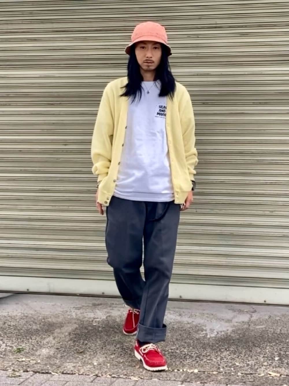 グレー系のチノパンツ、ホワイト系のTシャツ/カットソー、イエロー系のカーディガン/ボレロを着用したメンズの秋コーディネートの2枚目の写真