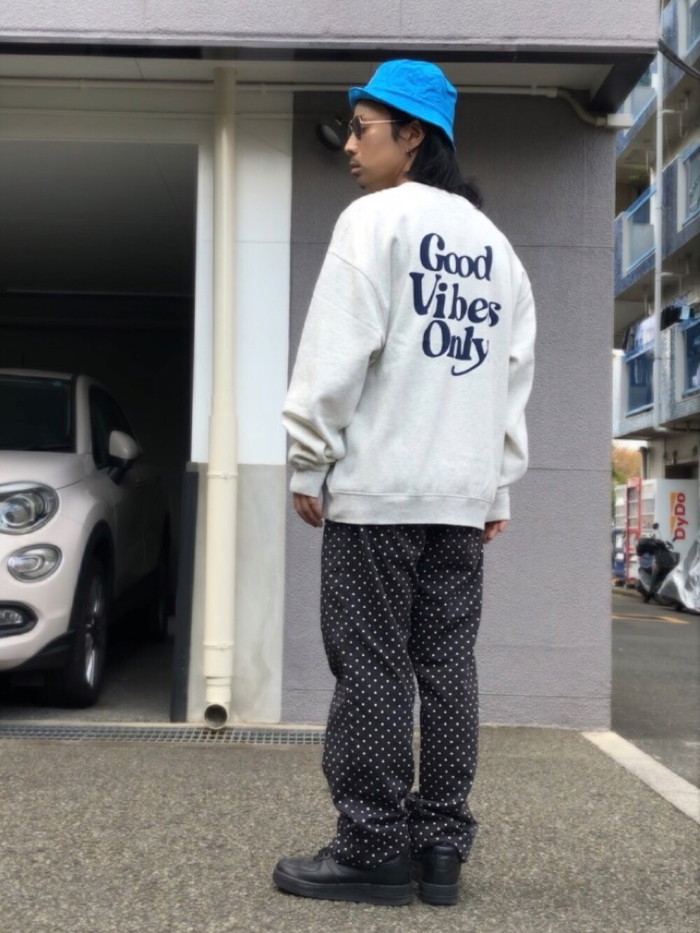 ホワイト系のスニーカー、ベージュ系のスウェット、ブラック系のチノパンツを着用したメンズの春コーディネートの3枚目の写真