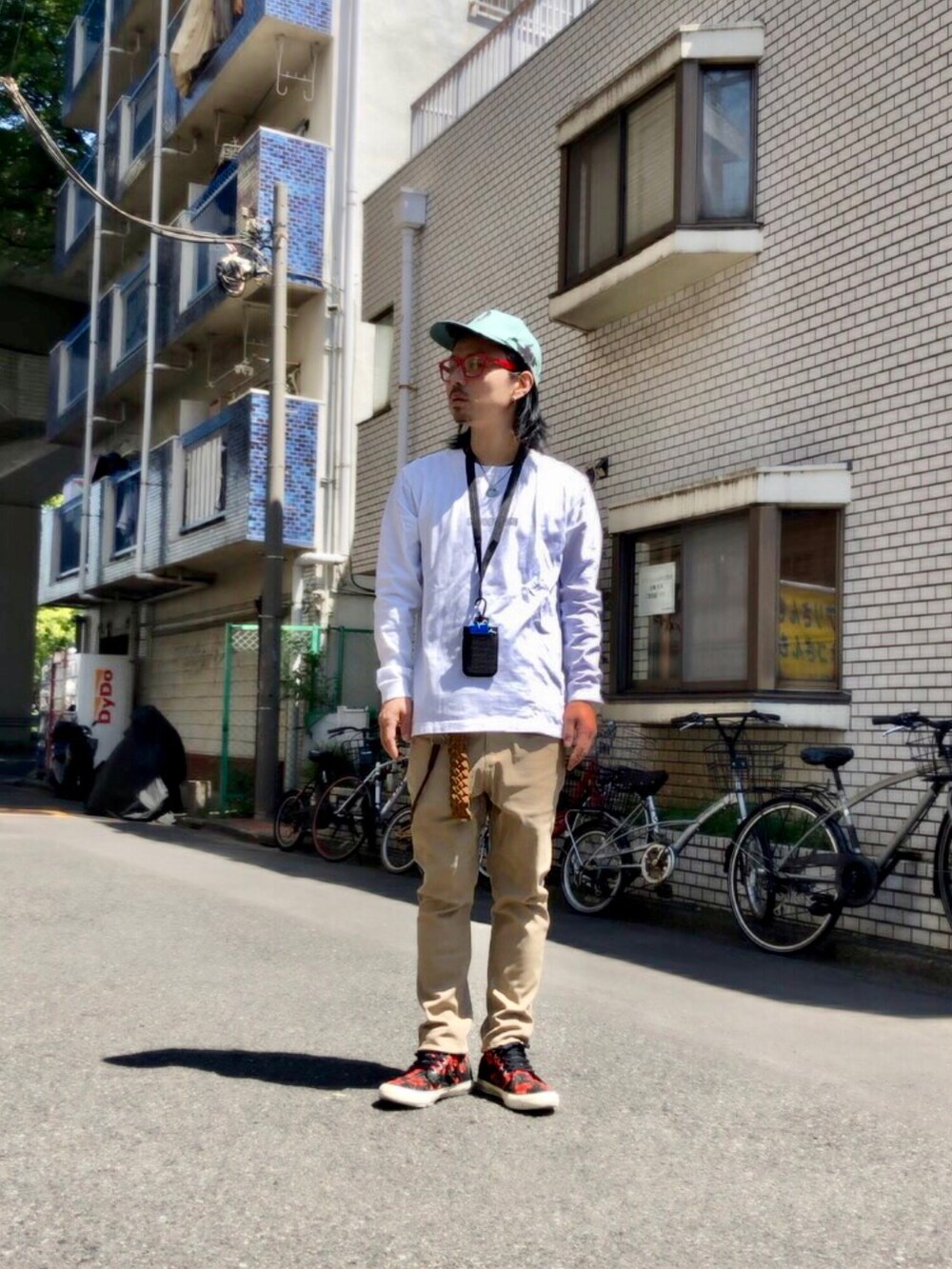 ホワイト系のTシャツ/カットソー、ベージュ系のチノパンツ、その他のスニーカーを着用したメンズの春コーディネートの5枚目の写真