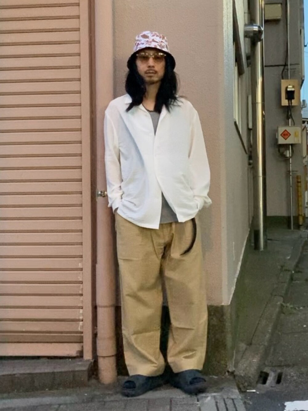 ブラック系のサンダル、ホワイト系のシャツ/ブラウス、ベージュ系のチノパンツを着用したメンズの夏コーディネートの4枚目の写真