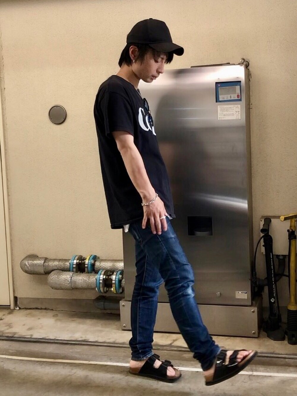 ブラック系のTシャツ/カットソー、ブルー系のデニムパンツ、ブラック系のキャップを着用したメンズの夏コーディネートの2枚目の写真