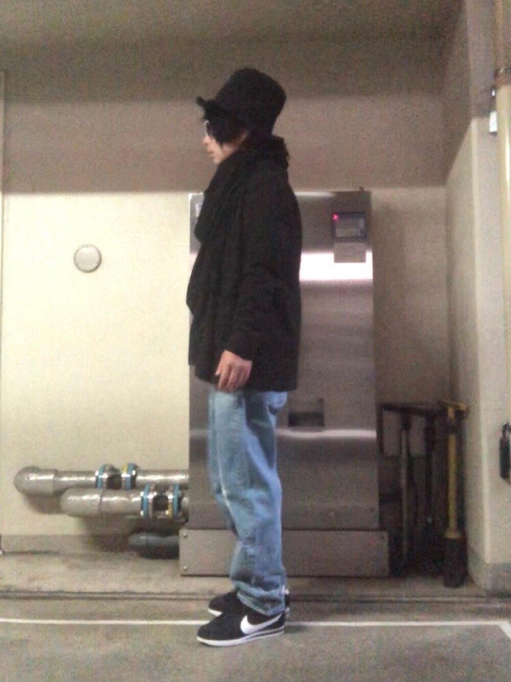 ブルー系のデニムパンツ、ブラック系のスニーカー、ブラック系のストール/ショールを着用したメンズの秋コーディネートの2枚目の写真