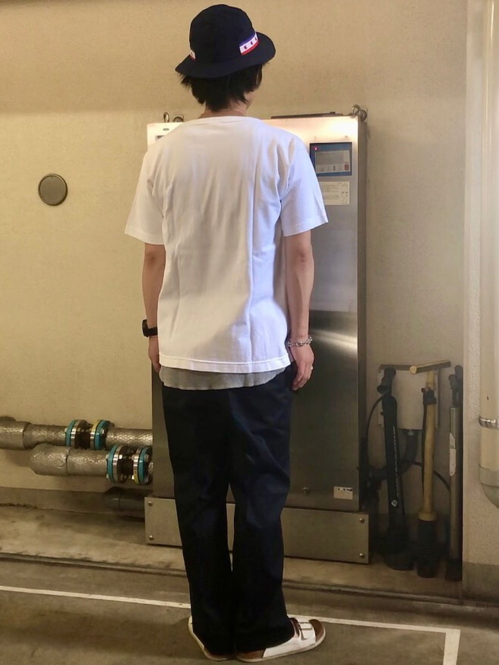 ホワイト系のTシャツ/カットソー、ブルー系のチノパンツ、ホワイト系のサンダルを着用したメンズの夏コーディネートの3枚目の写真