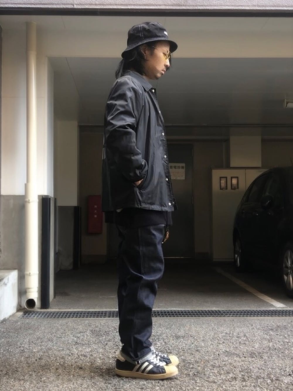 ブラック系のナイロンジャケット、ブラック系のニット/セーター、ブラック系のスニーカーを着用したメンズの冬コーディネートの2枚目の写真