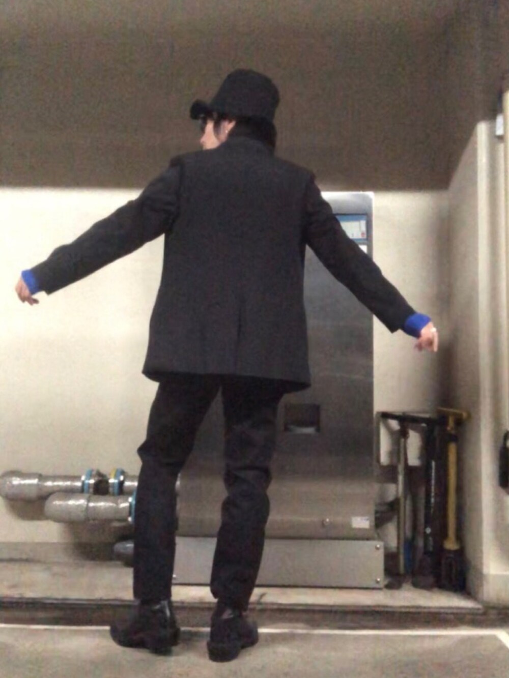 ブラック系のデニムパンツ、ブラック系のブーツ、ブラック系のハットを着用したメンズの秋コーディネートの3枚目の写真