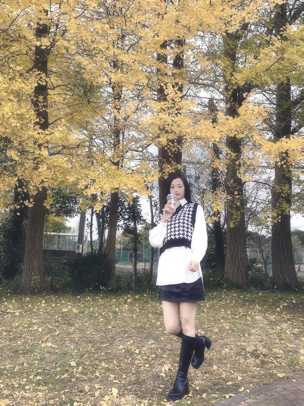 ブラック系のベスト、ブラック系のスカート、ブラック系のブーツを着用したレディースの冬コーディネートの2枚目の写真