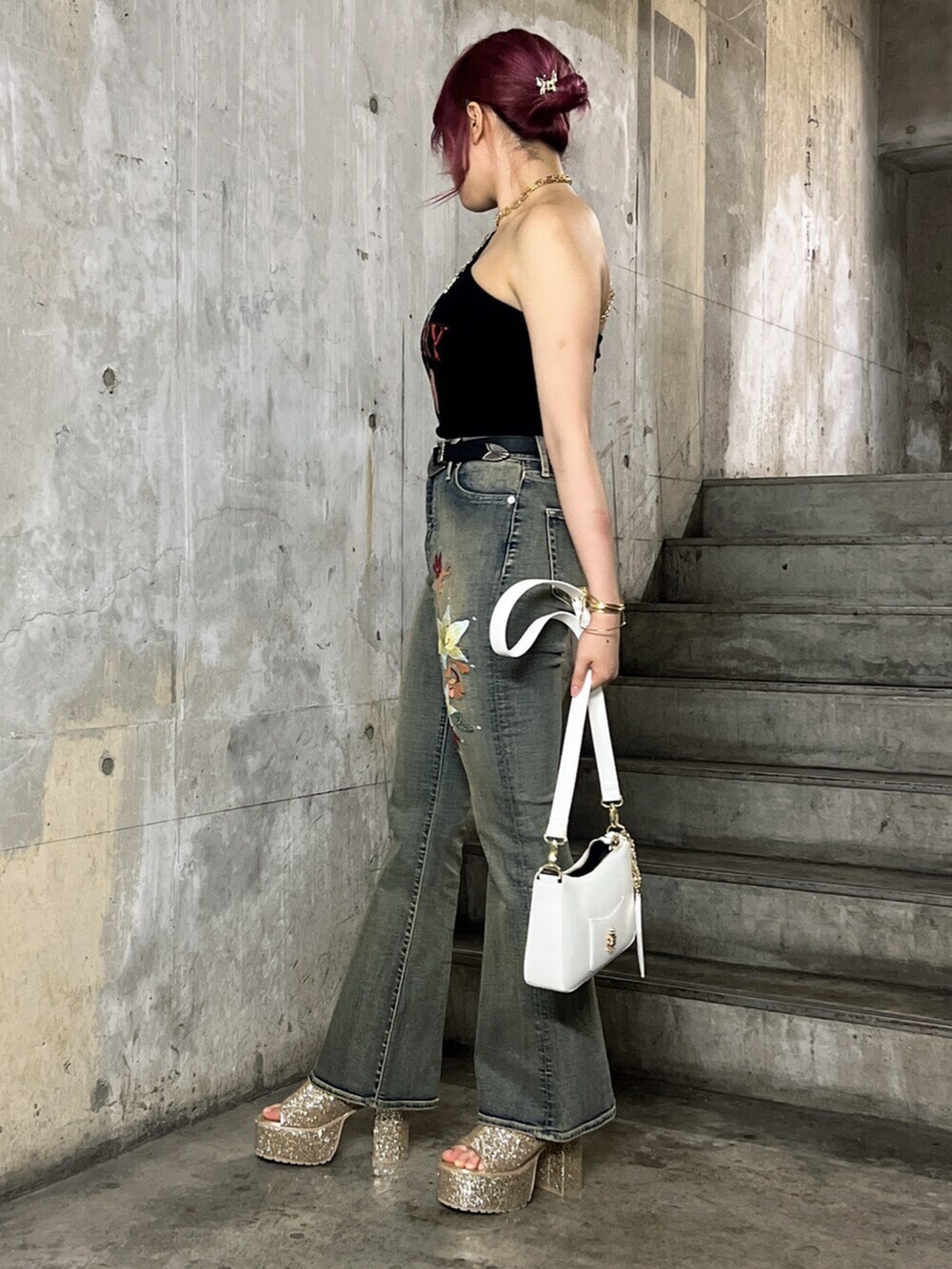 ブラック系のキャミソール、ホワイト系のショルダーバッグ、ブルー系のデニムパンツを着用したレディースの夏コーディネートの2枚目の写真