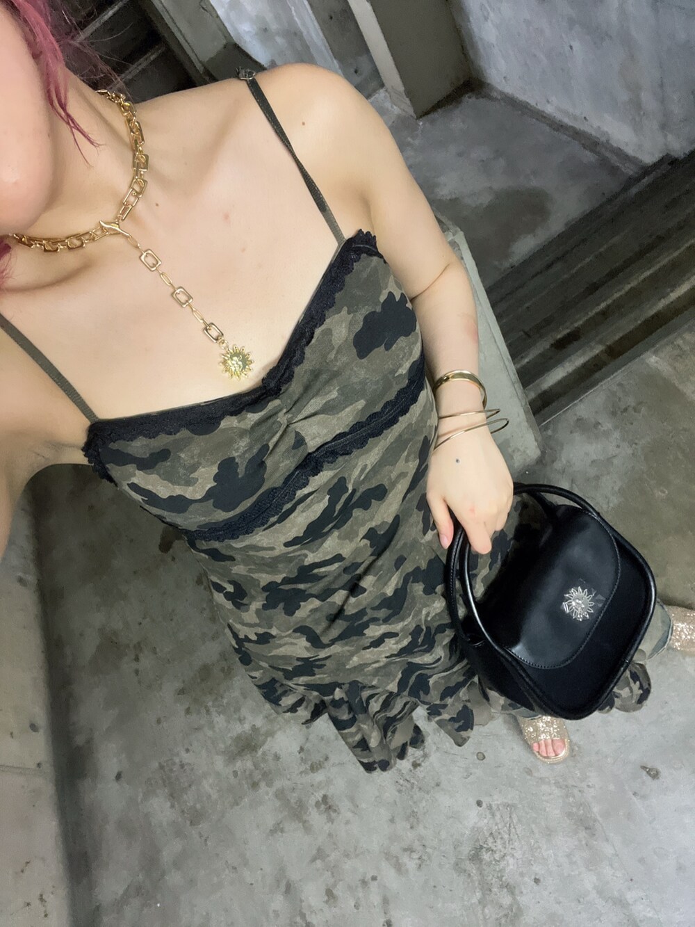 グリーン系のワンピース、ブラック系のハンドバッグ、ブルー系のデニムパンツを着用したレディースの夏コーディネートの6枚目の写真