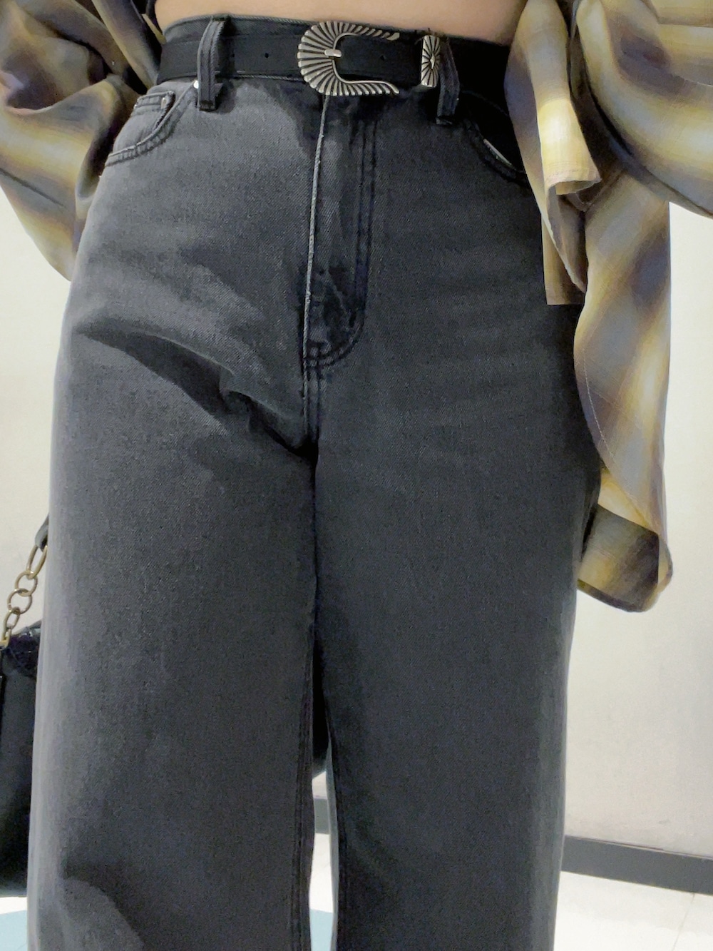 ブラック系のワンピース、イエロー系のシャツ/ブラウス、ブラック系のデニムパンツを着用したレディースの秋コーディネートの5枚目の写真