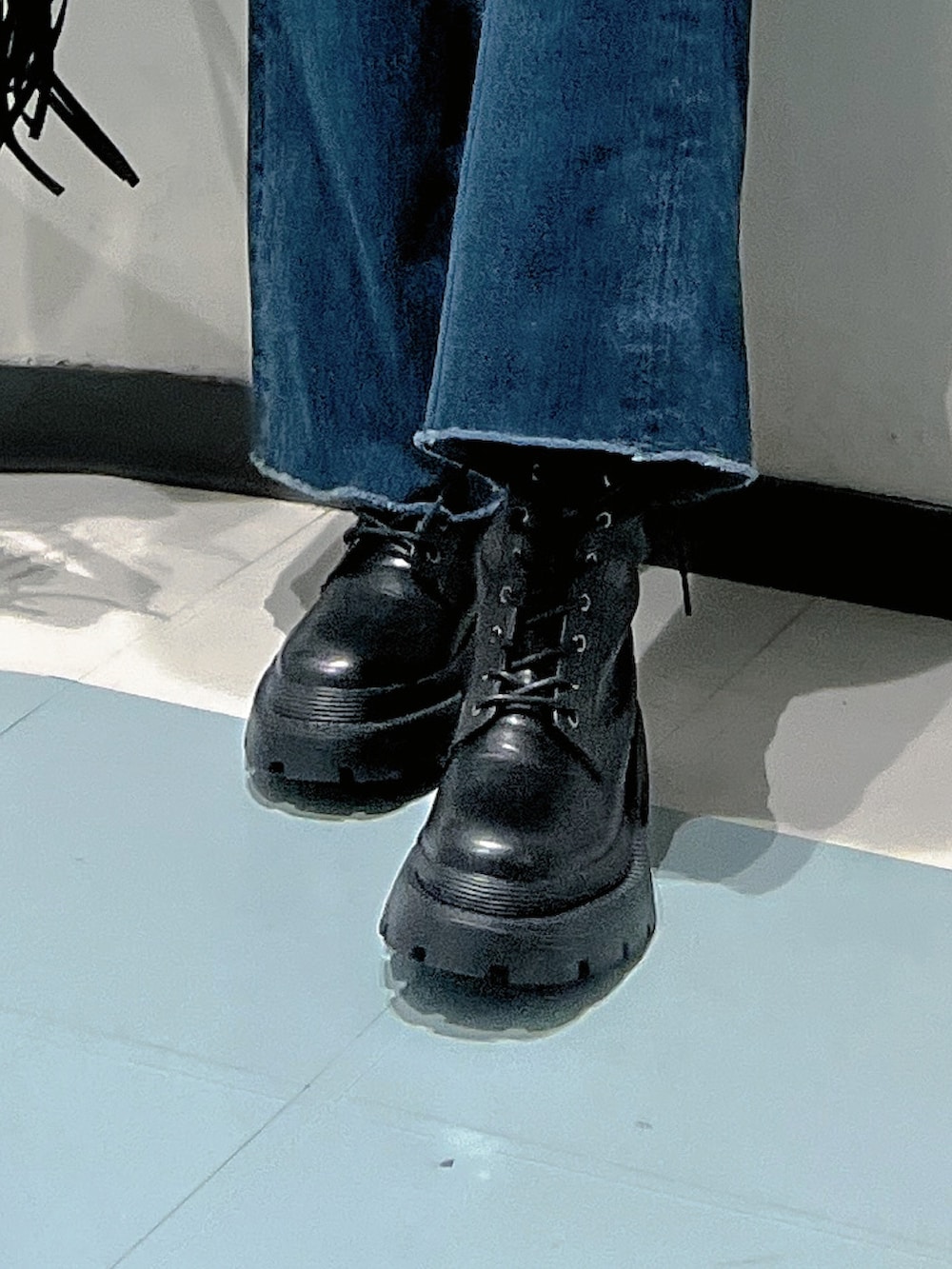 ブルー系のニット/セーター、ブルー系のデニムパンツ、ブラック系のショルダーバッグを着用したレディースの秋コーディネートの6枚目の写真