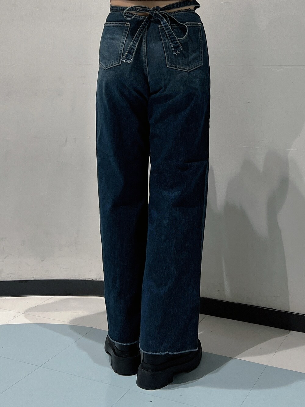 ブルー系のニット/セーター、ブルー系のデニムパンツ、ブラック系のショルダーバッグを着用したレディースの秋コーディネートの5枚目の写真