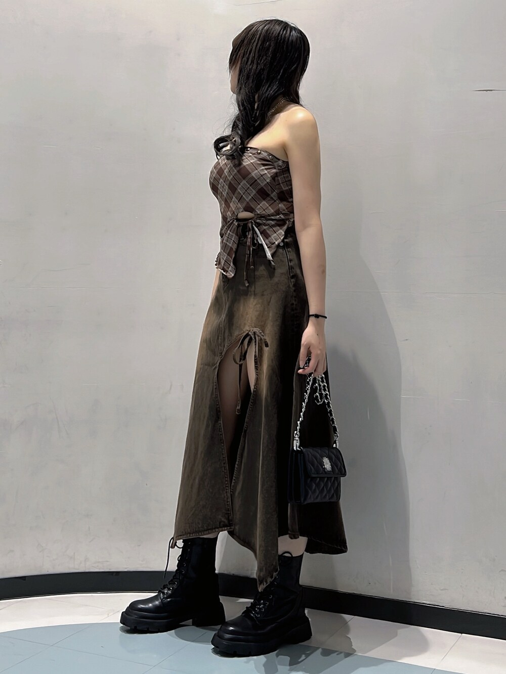 ブラウン系のキャミソール、ブラウン系のデニムスカート、ブラック系のハンドバッグを着用したレディースの秋コーディネートの2枚目の写真