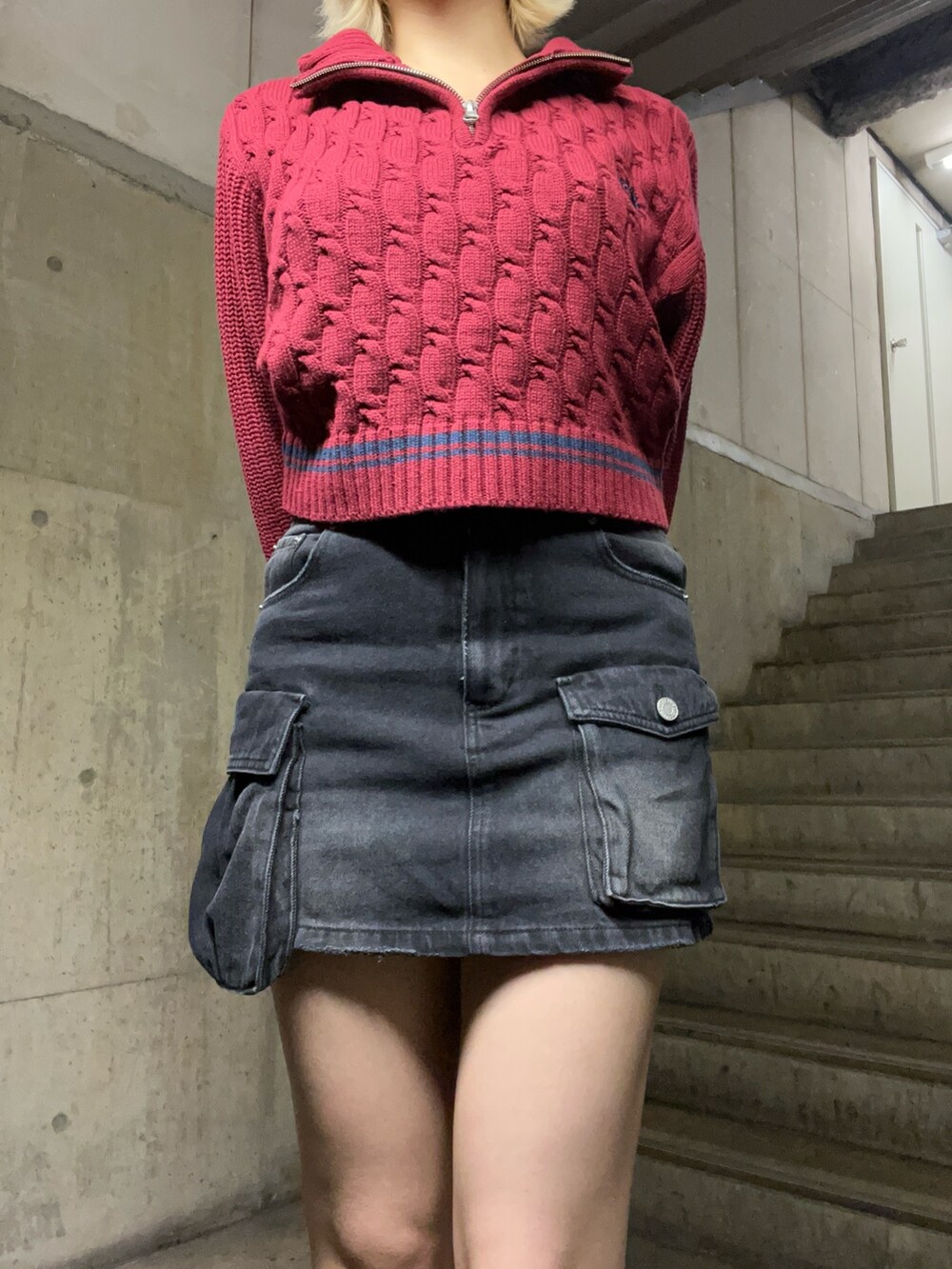 レッド系のニット/セーター、ピンク系のショルダーバッグ、ブラック系のデニムスカートを着用したレディースの秋コーディネートの5枚目の写真