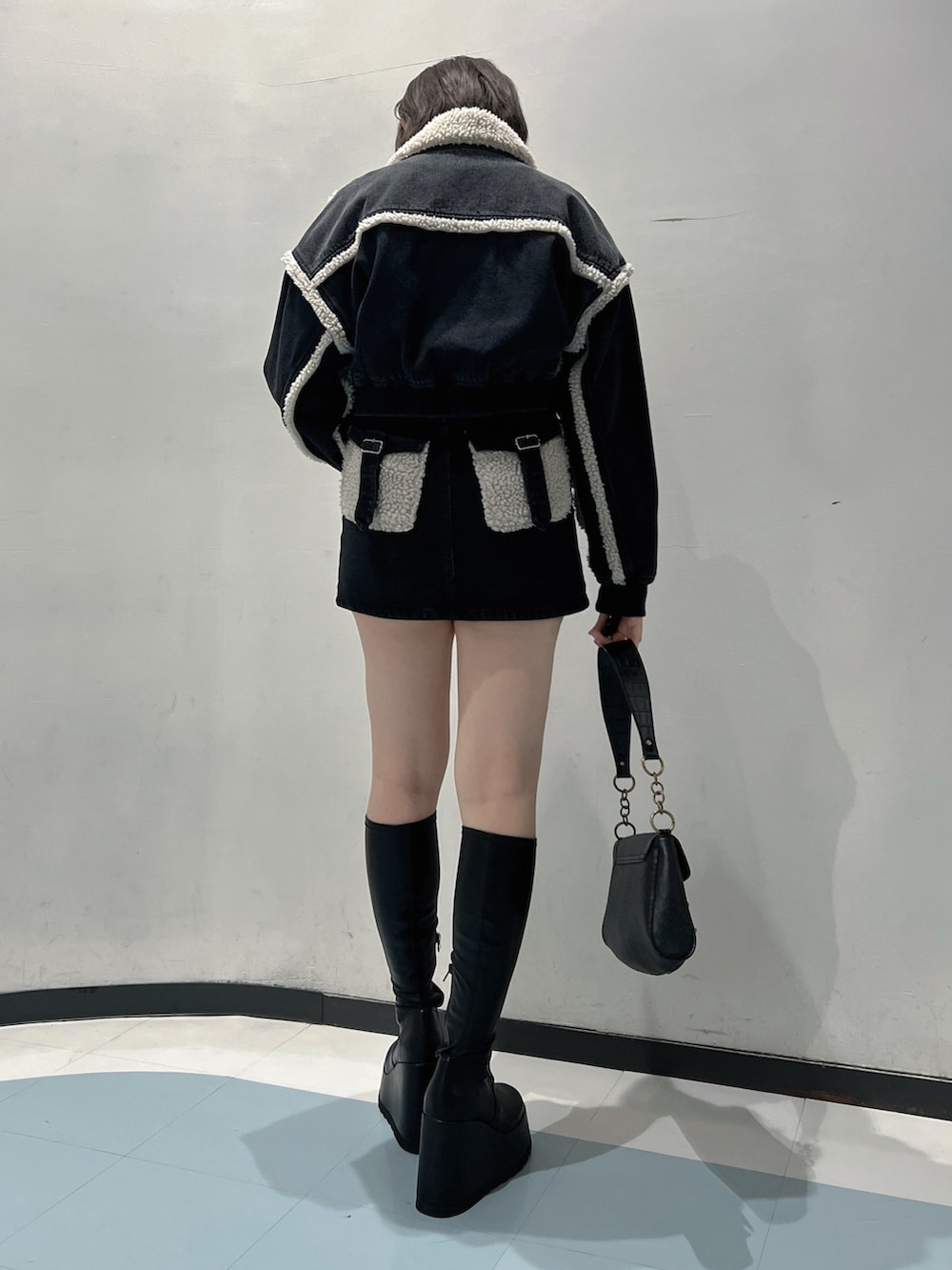 ブラック系のブルゾン、ブラック系のTシャツ/カットソー、ブラック系のデニムスカートを着用したレディースの秋コーディネートの3枚目の写真